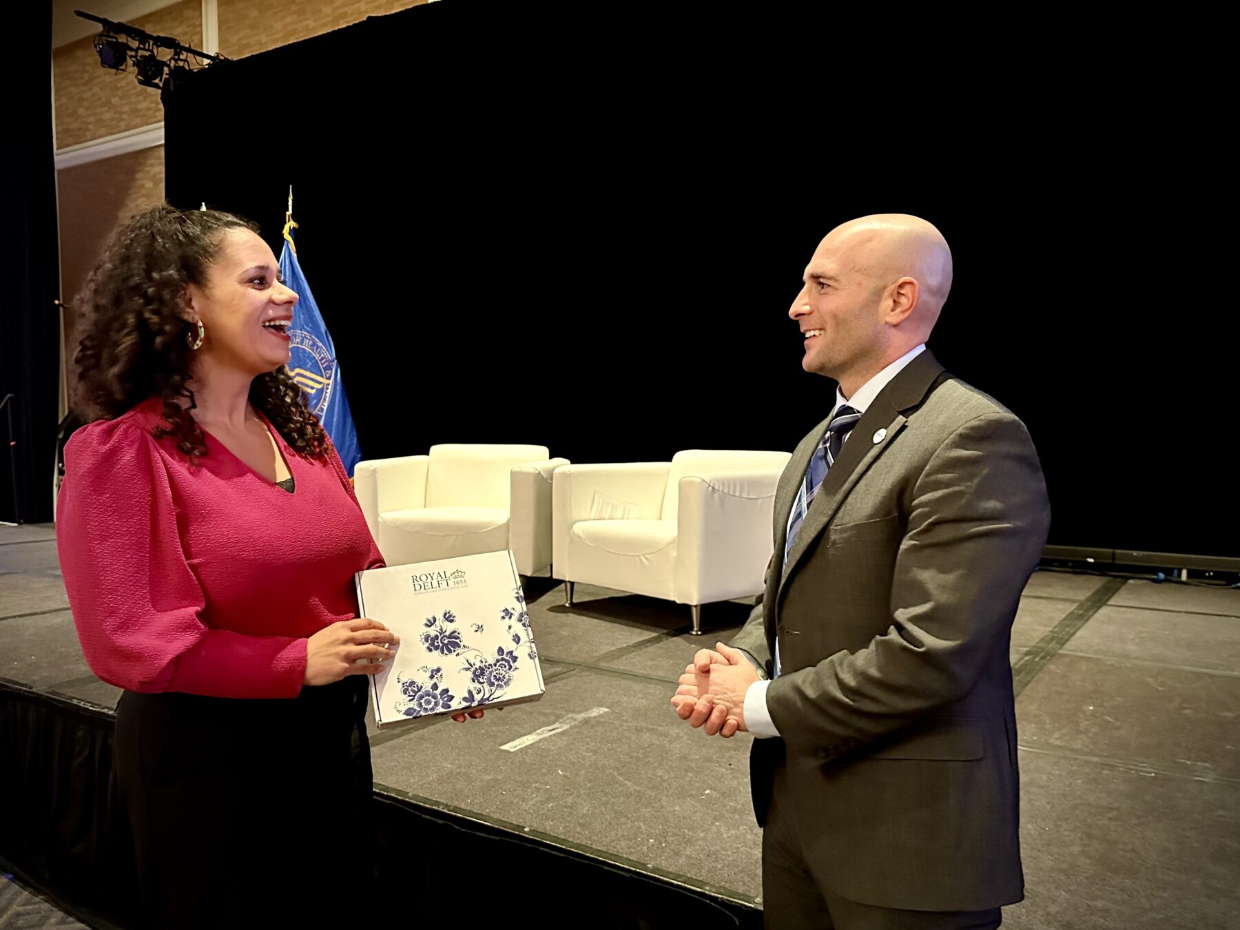 Photo of Steve Posnack, principal deputy assistant secretary for technology policy, US Depart for Health and Human Services (right) and Abigail Norville, deputy secretary general of The Netherlands Ministry of Health, Welfare and Sport (left) handing over the US Chair of the Global Digital Health partnership (GDHP) to NL.